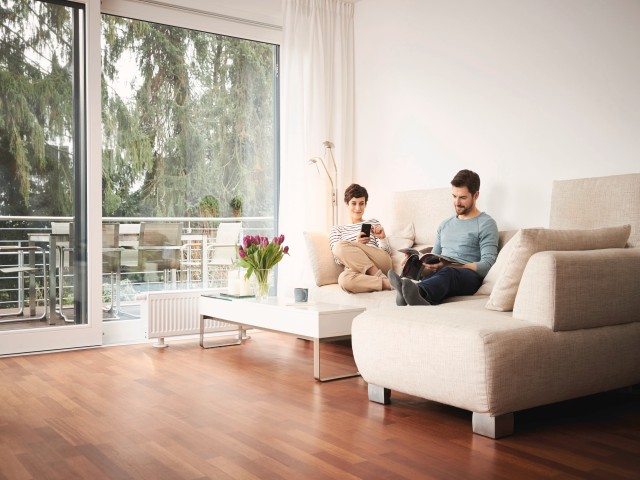 Pareja sentada en el sofá y leyendo