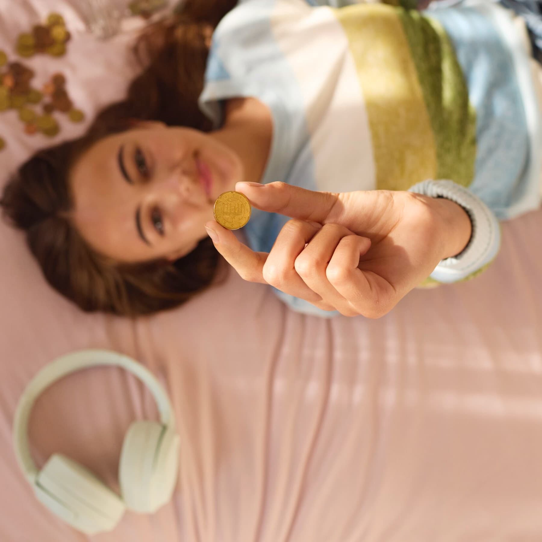 Chica contando dinero en la cama.