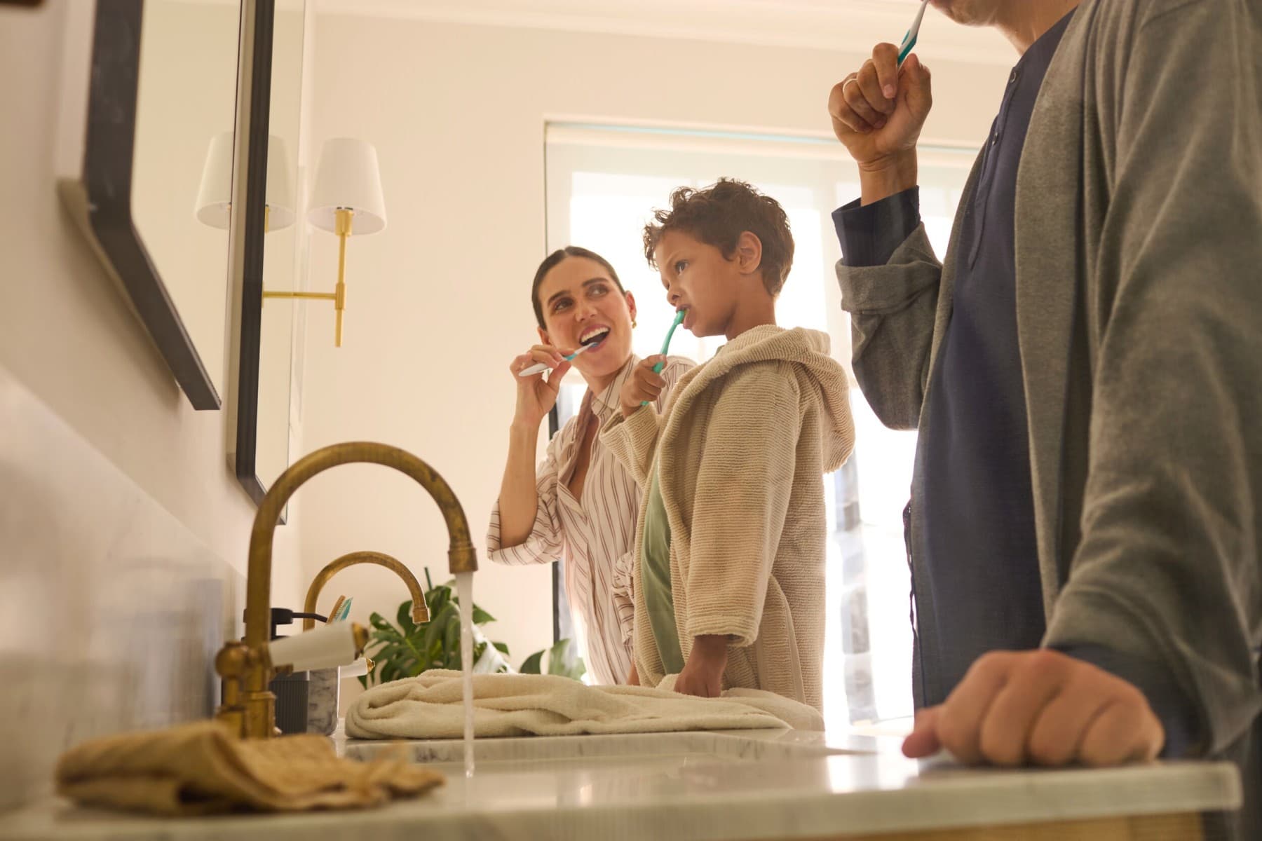 Una familia se está cepillando los dientes en el baño.
