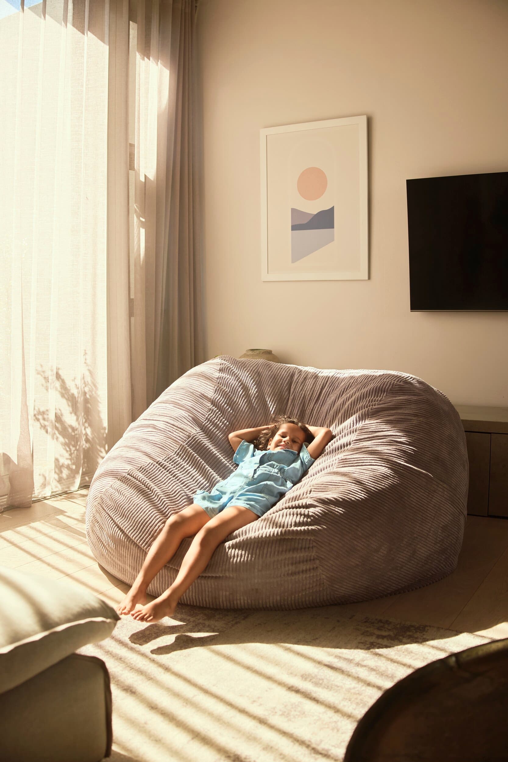 Una chica está descansando en un puf