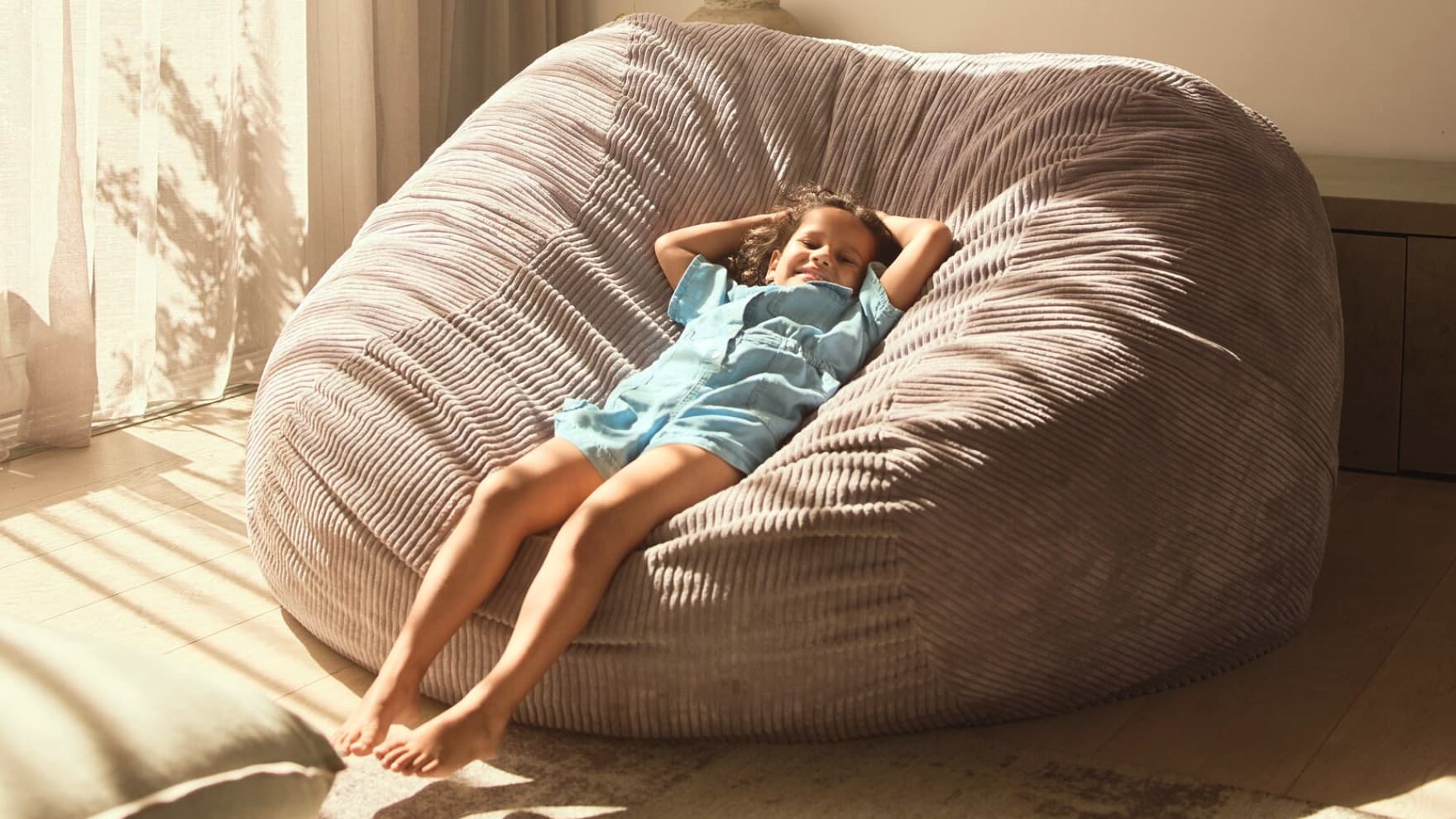 Un niño se relaja sobre un sofá acolchado gigante.