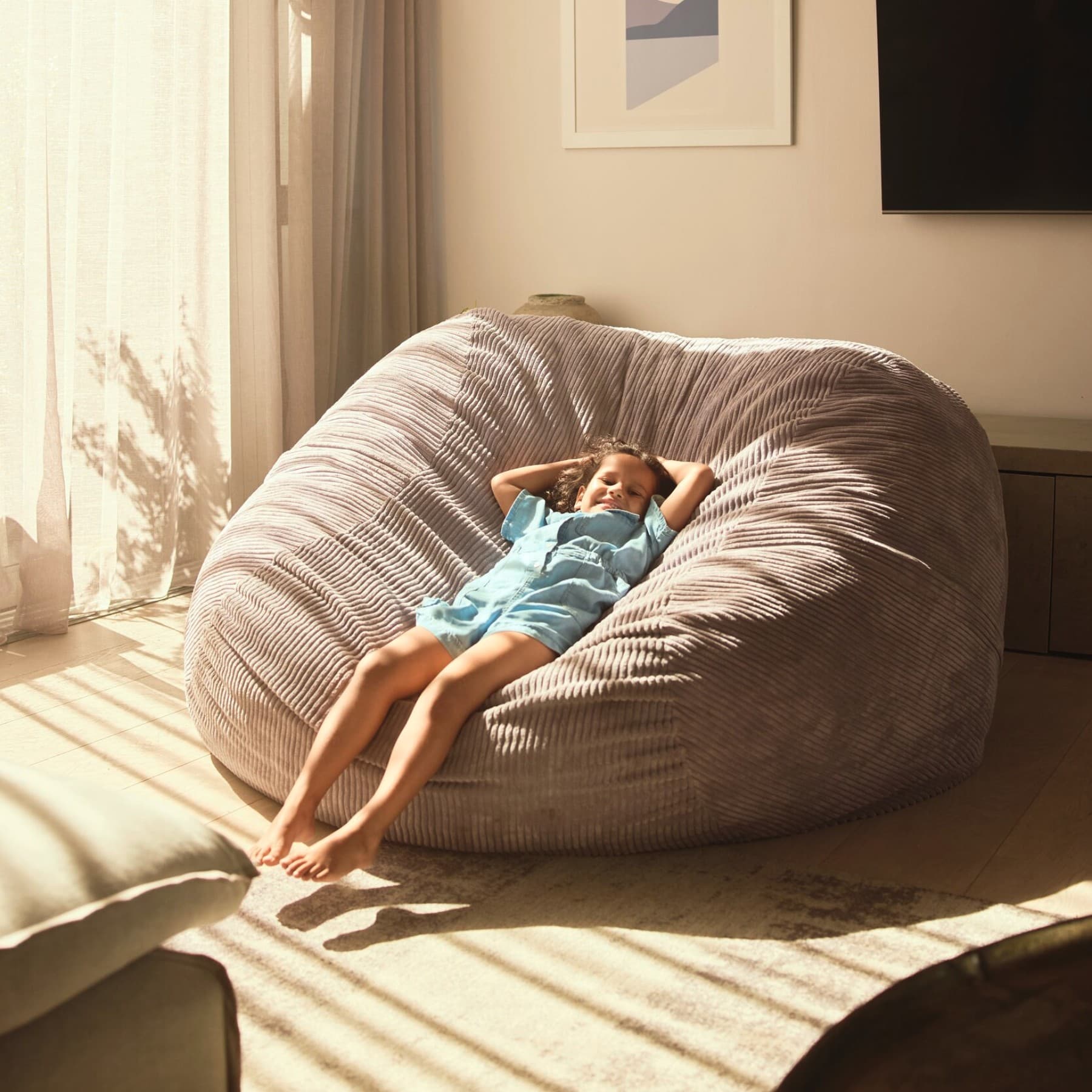 Un niño descansando en un puf