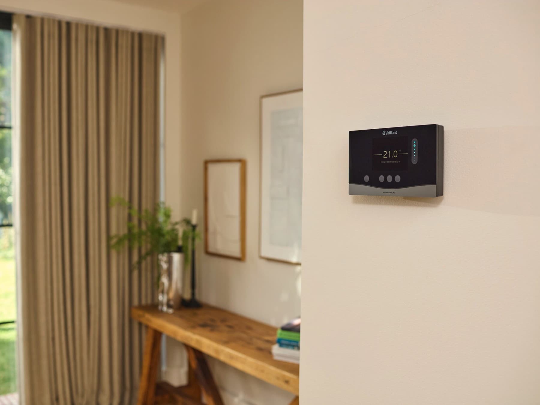 Un moderno termostato Vaillant en la pared de una sala de estar.