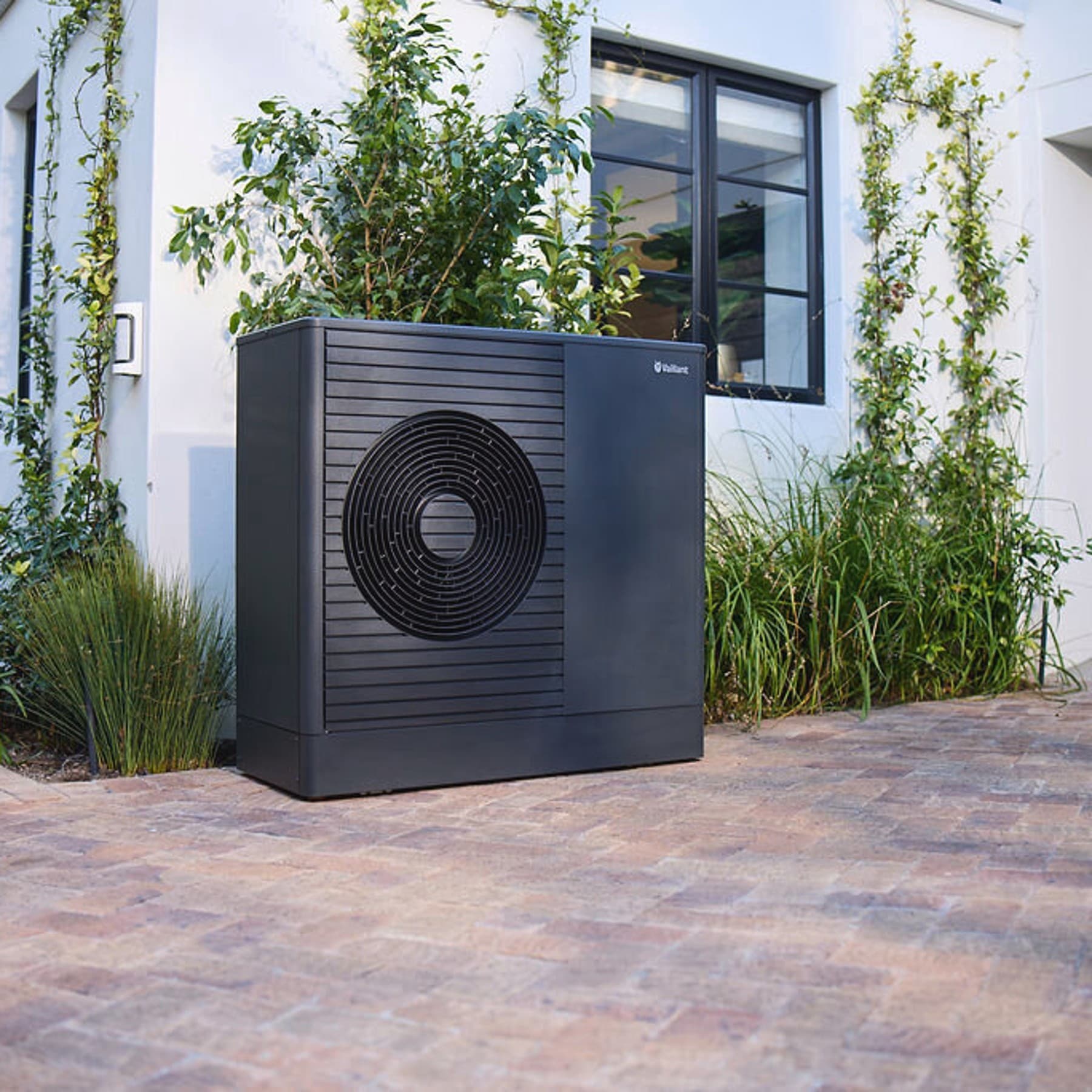 Bomba de calor Vaillant aroTHERM exclusive ES en el jardín delantero de una casa.
