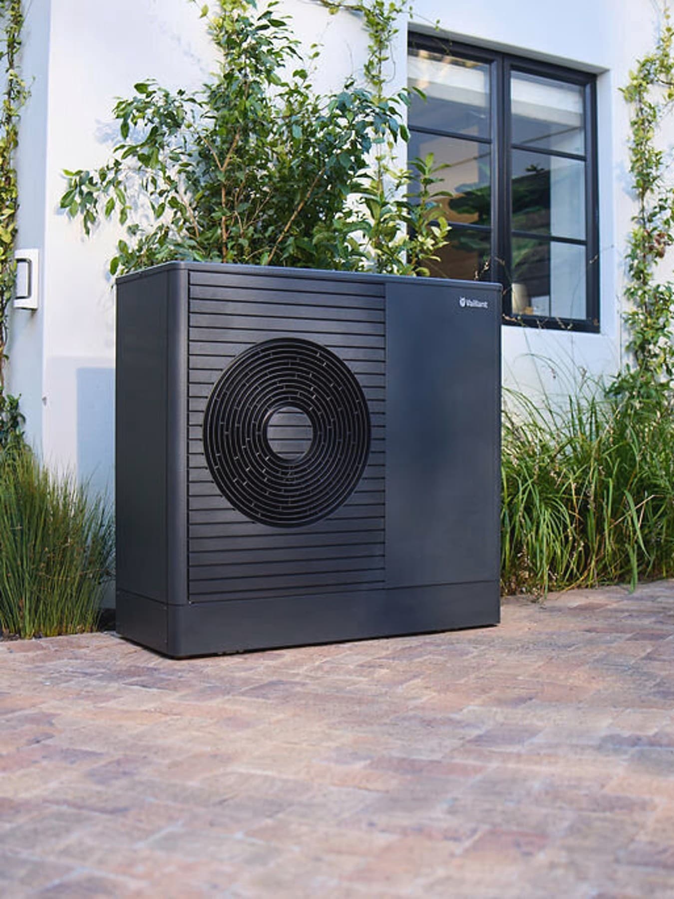 Bomba de calor Vaillant aroTHERM exclusive ES en el jardín delantero de una casa.