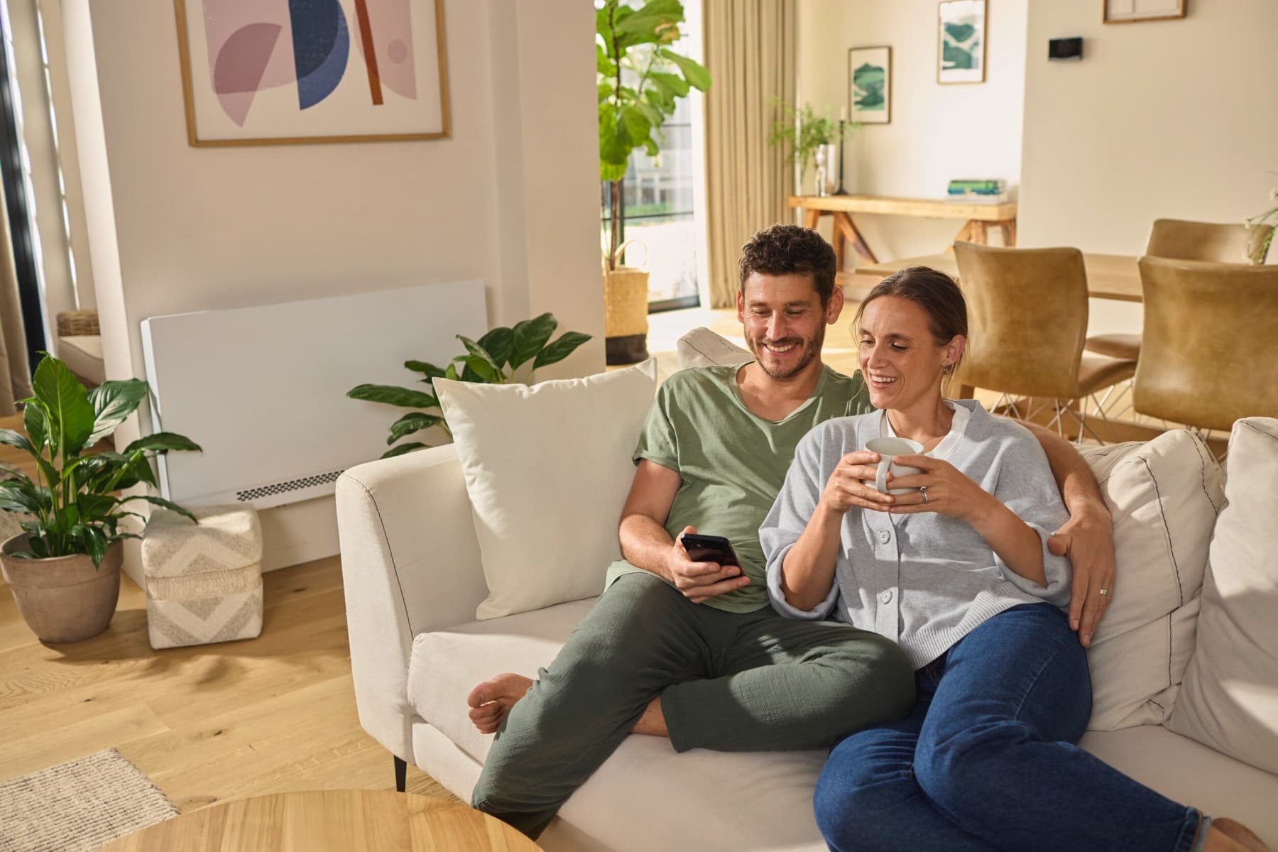 Pareja sentada en el sofá mirando un smartphone