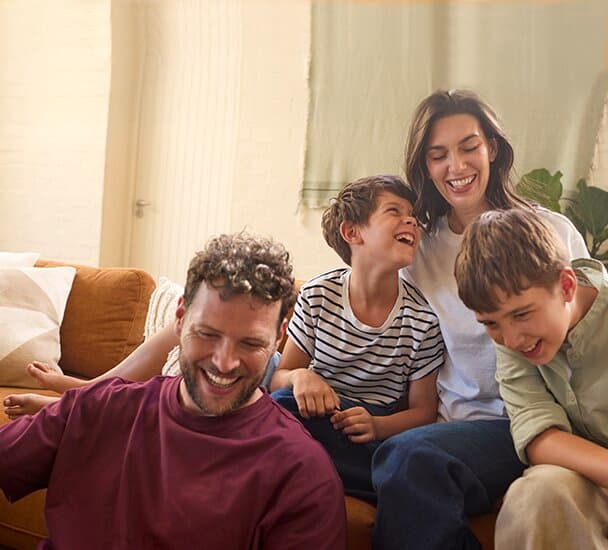 Una familia sentada en el sofá del salón