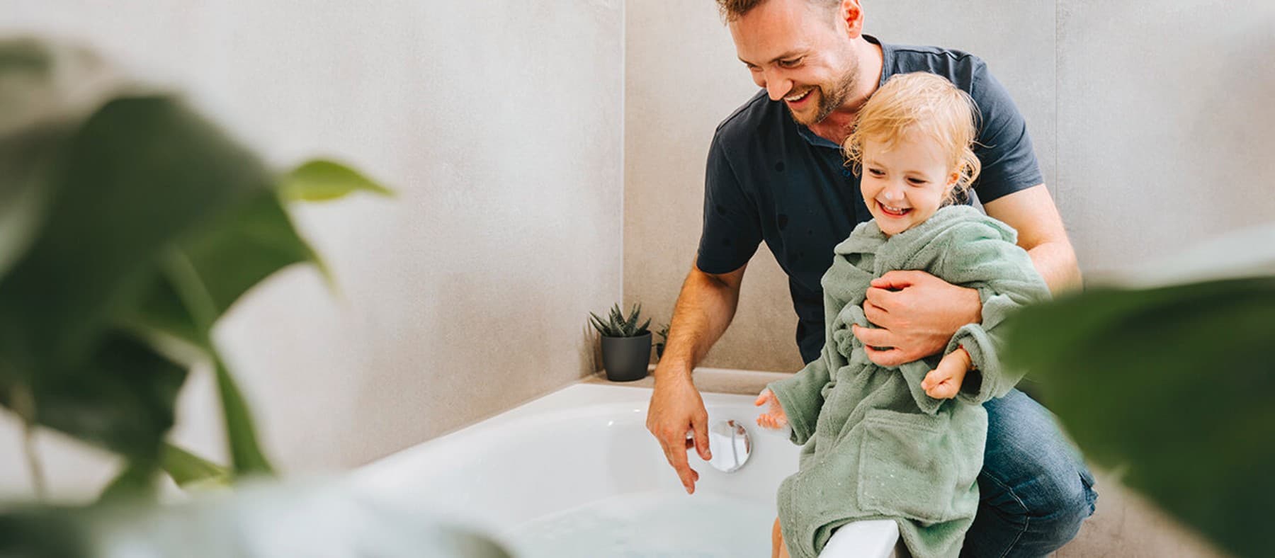 Un padre y su hija disfrutan de agua constantemente caliente en el cuarto de baño.