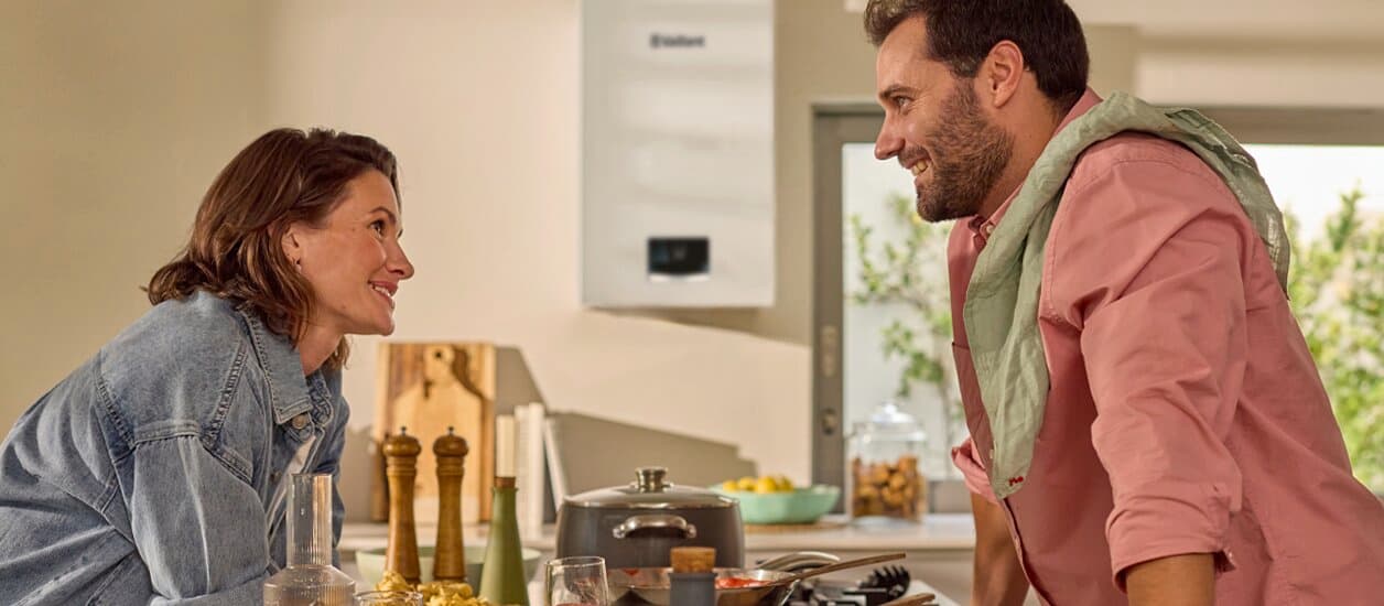 Una pareja de pie en la cocina mirándose el uno al otro