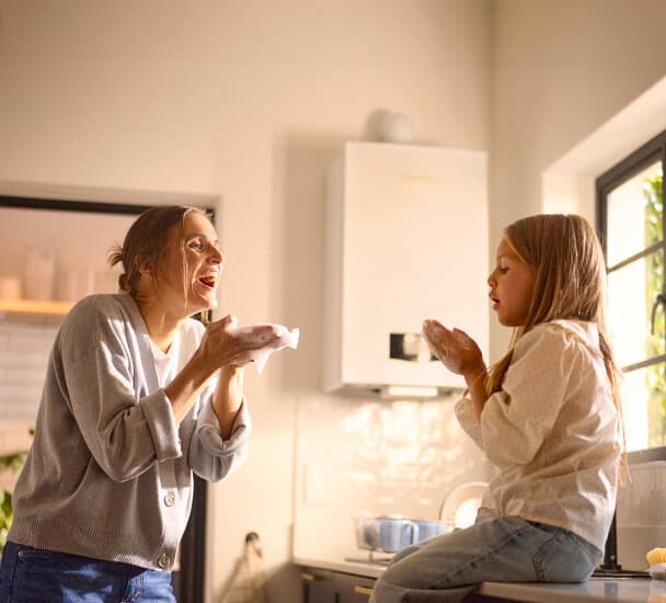 La madre y la hija están jugando con pompas de jabón