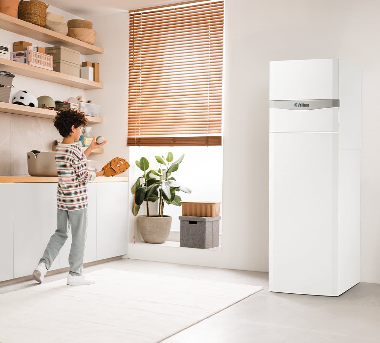 Un niño juega en un cuarto de servicio con el Vaillant flexoCOMPACT exclusive