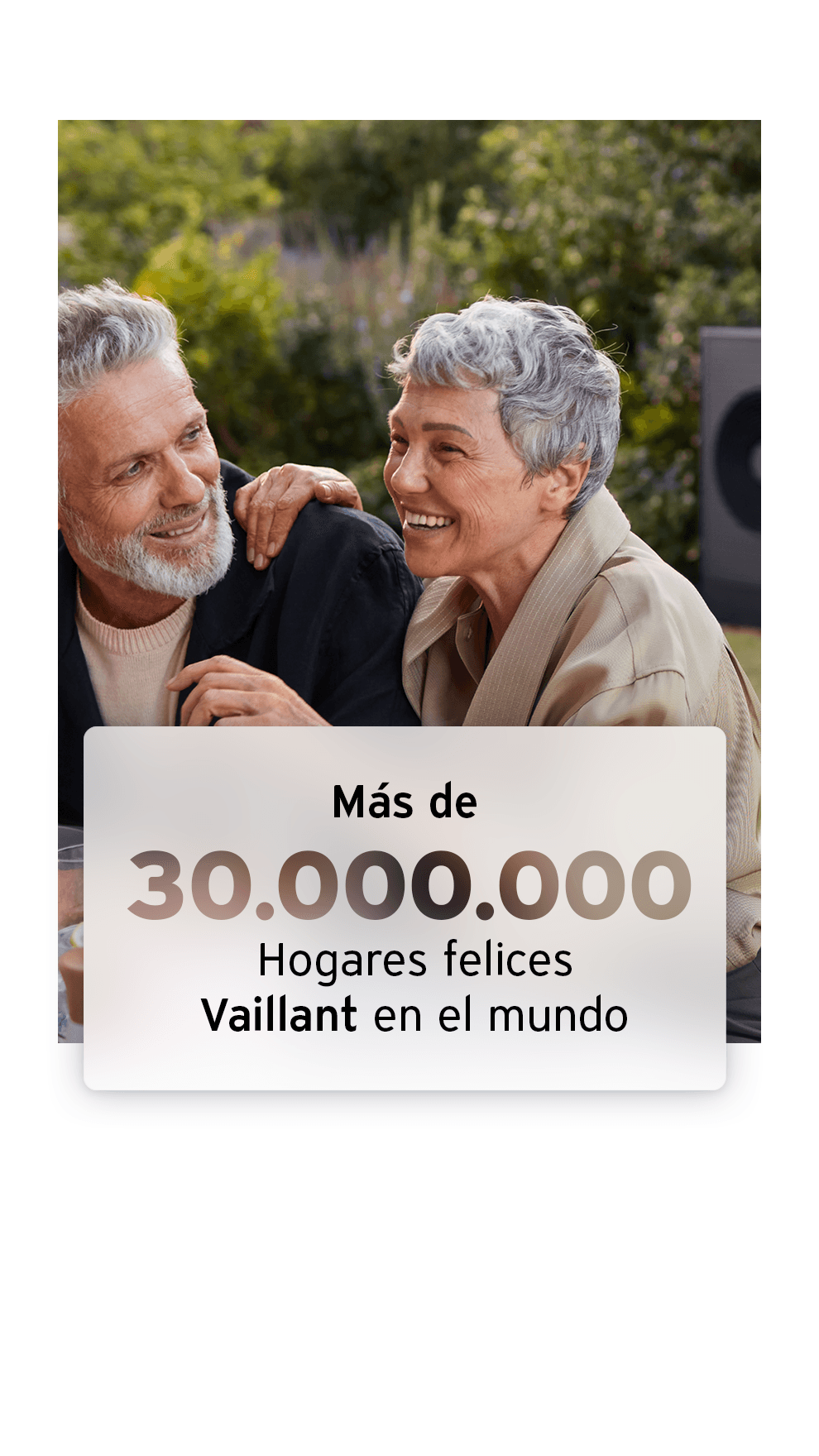 Pareja disfrutando de su jardín con una bomba de calor aerotérmica en el fondo