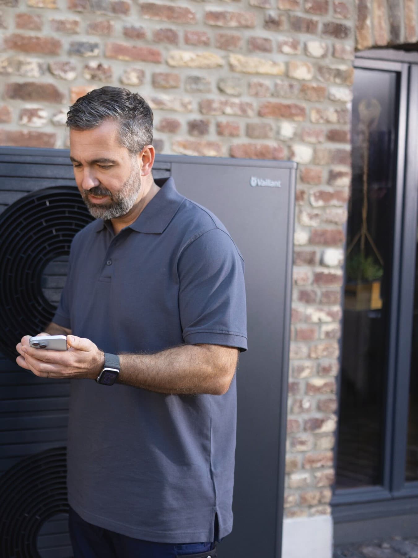 Instalador y propietario mirando un teléfono inteligente.