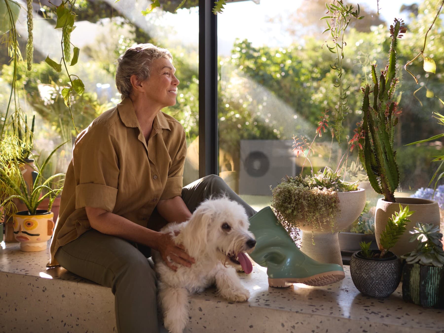 Mujer sentada con su perro en la ventana