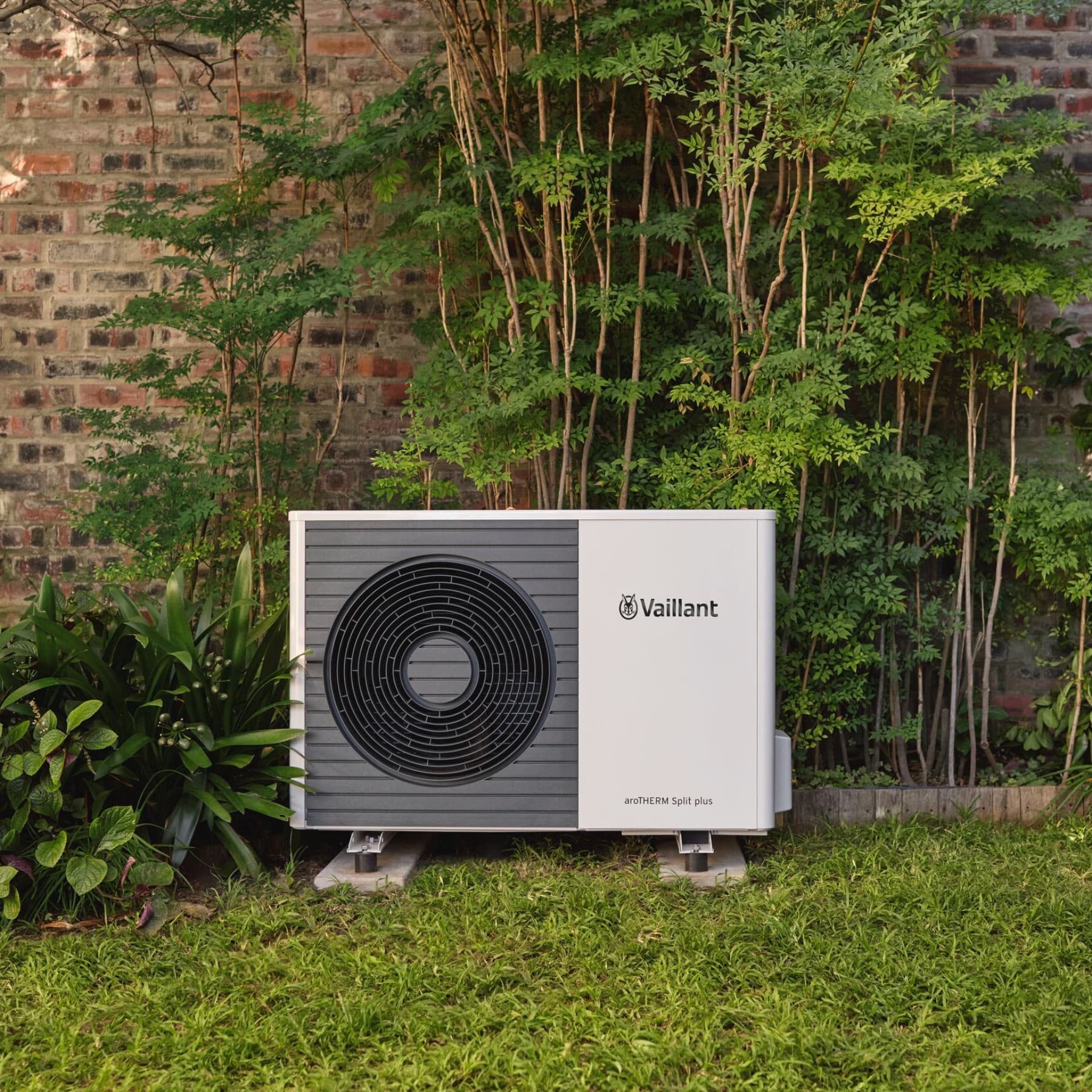 Una unidad exterior de bomba de calor en un jardín.
