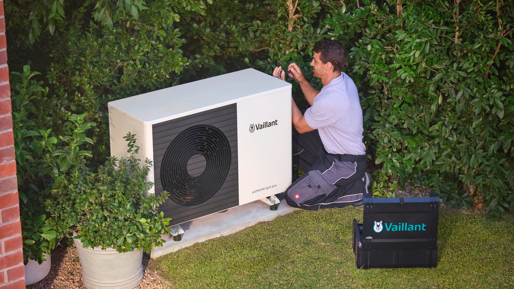 Un instalador comprueba una bomba de calor con una herramienta.
