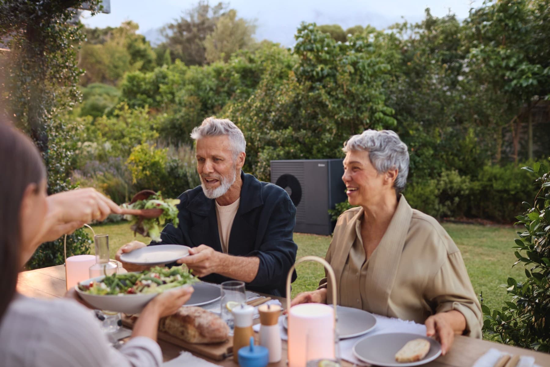 Matrimonio disfrutando en su jardín de haber elegido aerotermia Vaillant para su hogar