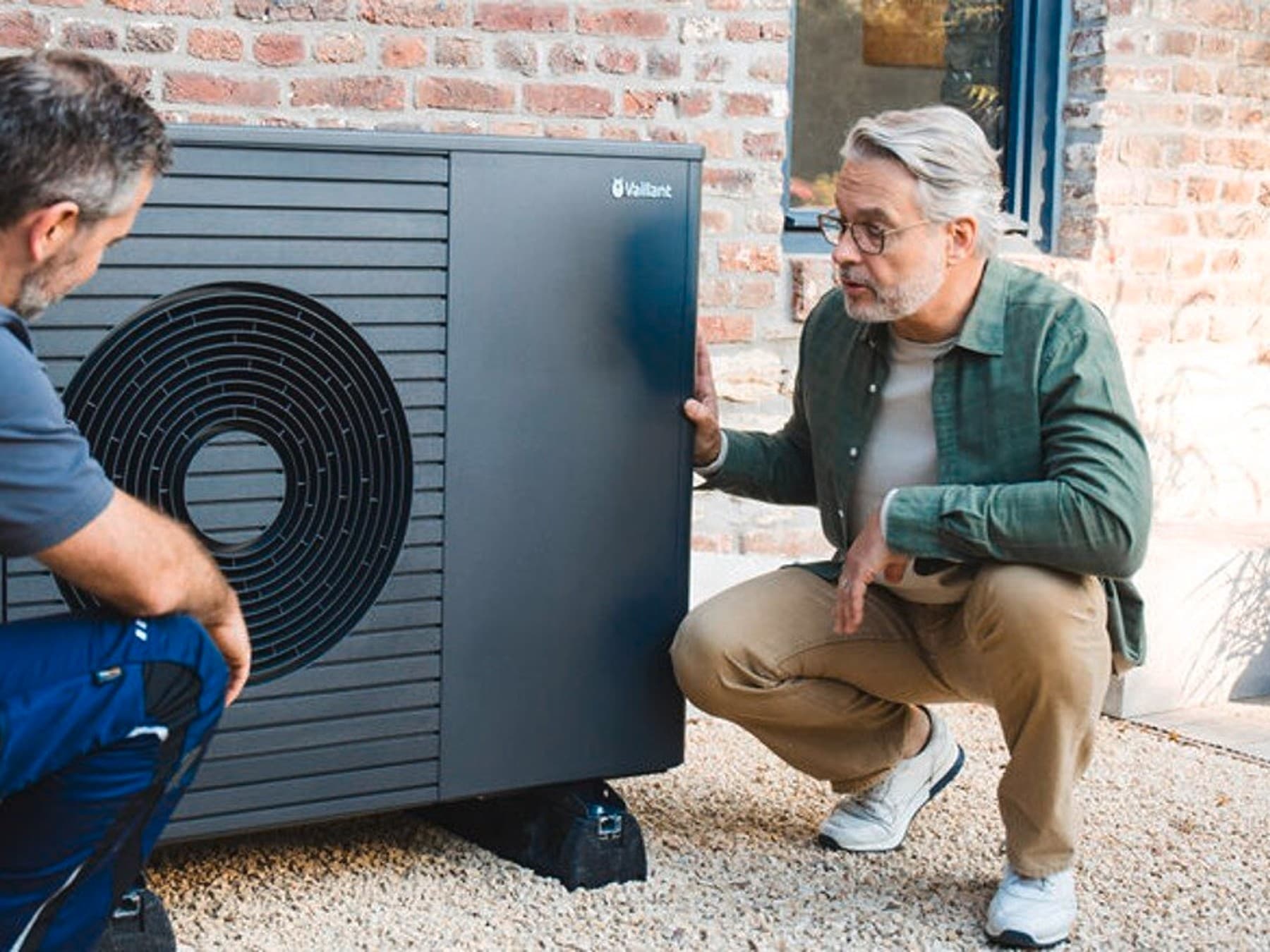 instalador y propietario de una vivienda junto a una bomba de calor