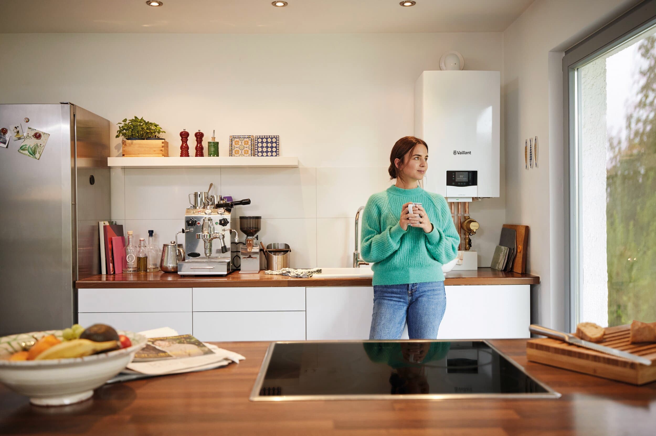 Mujer en la cocina con una caldera de fondo