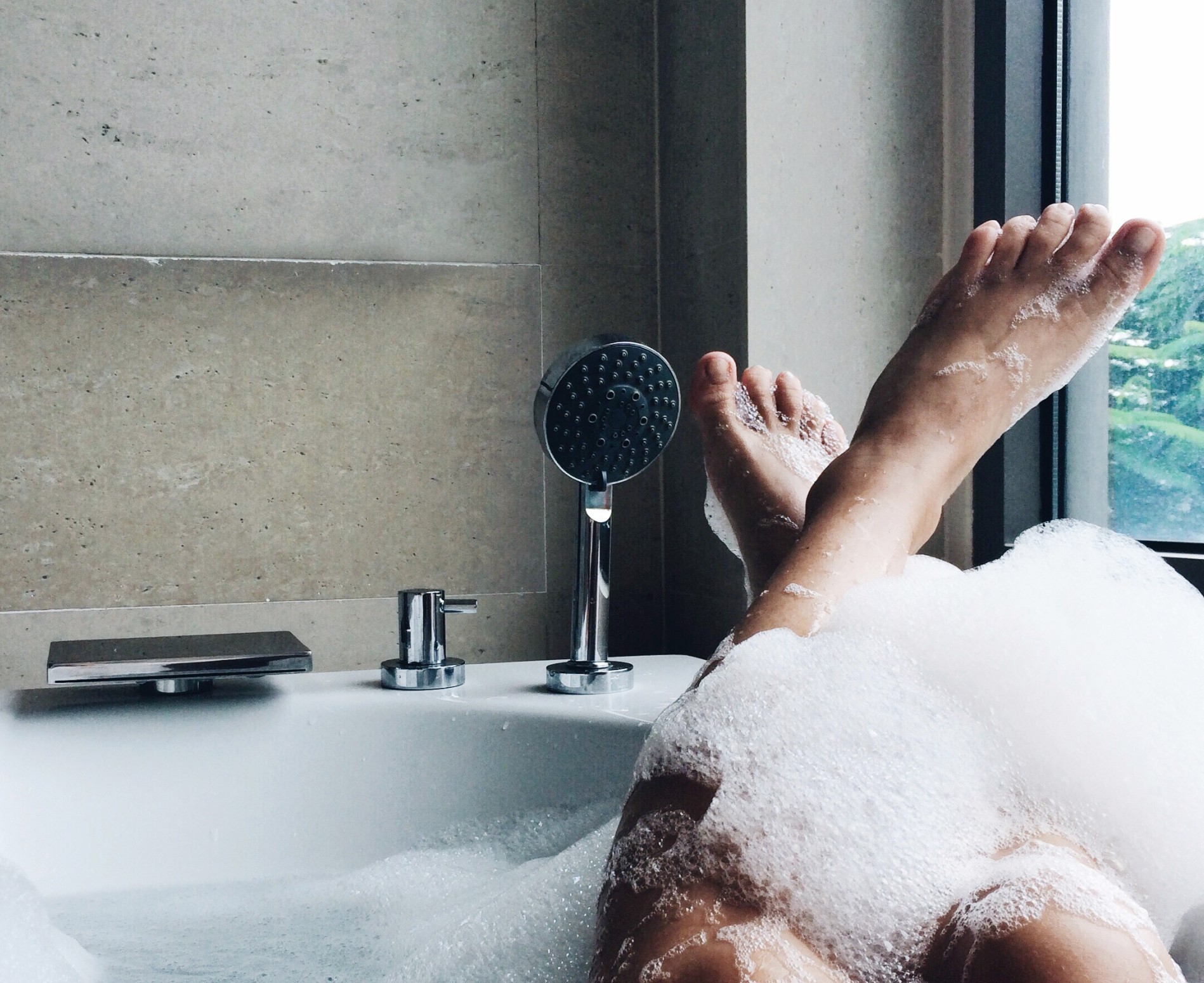 female feet laying out of a bathtub